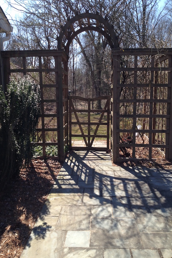 Wood garden arbor and gate at a walkway